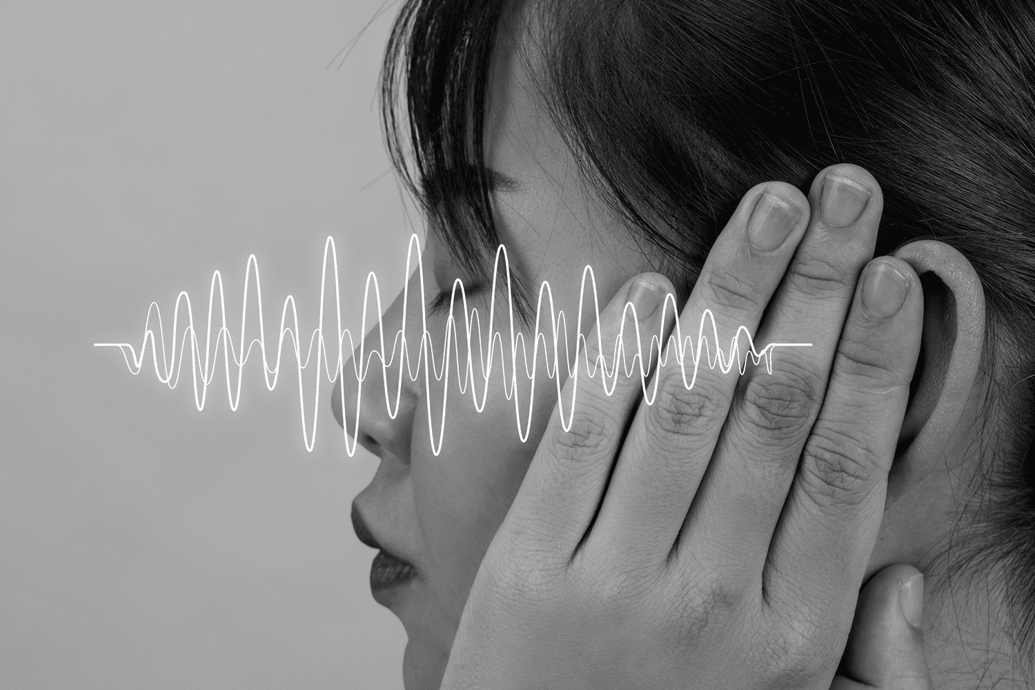 Primo piano di una persona che si copre un orecchio, con onde sonore sovrapposte a rappresentare rumore, riverbero e disturbi acustici che compromettono l’ascolto.