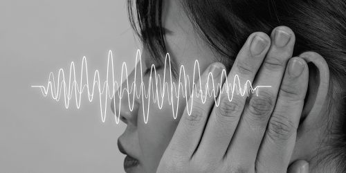 Primo piano di una persona che si copre un orecchio, con onde sonore sovrapposte a rappresentare rumore, riverbero e disturbi acustici che compromettono l’ascolto.